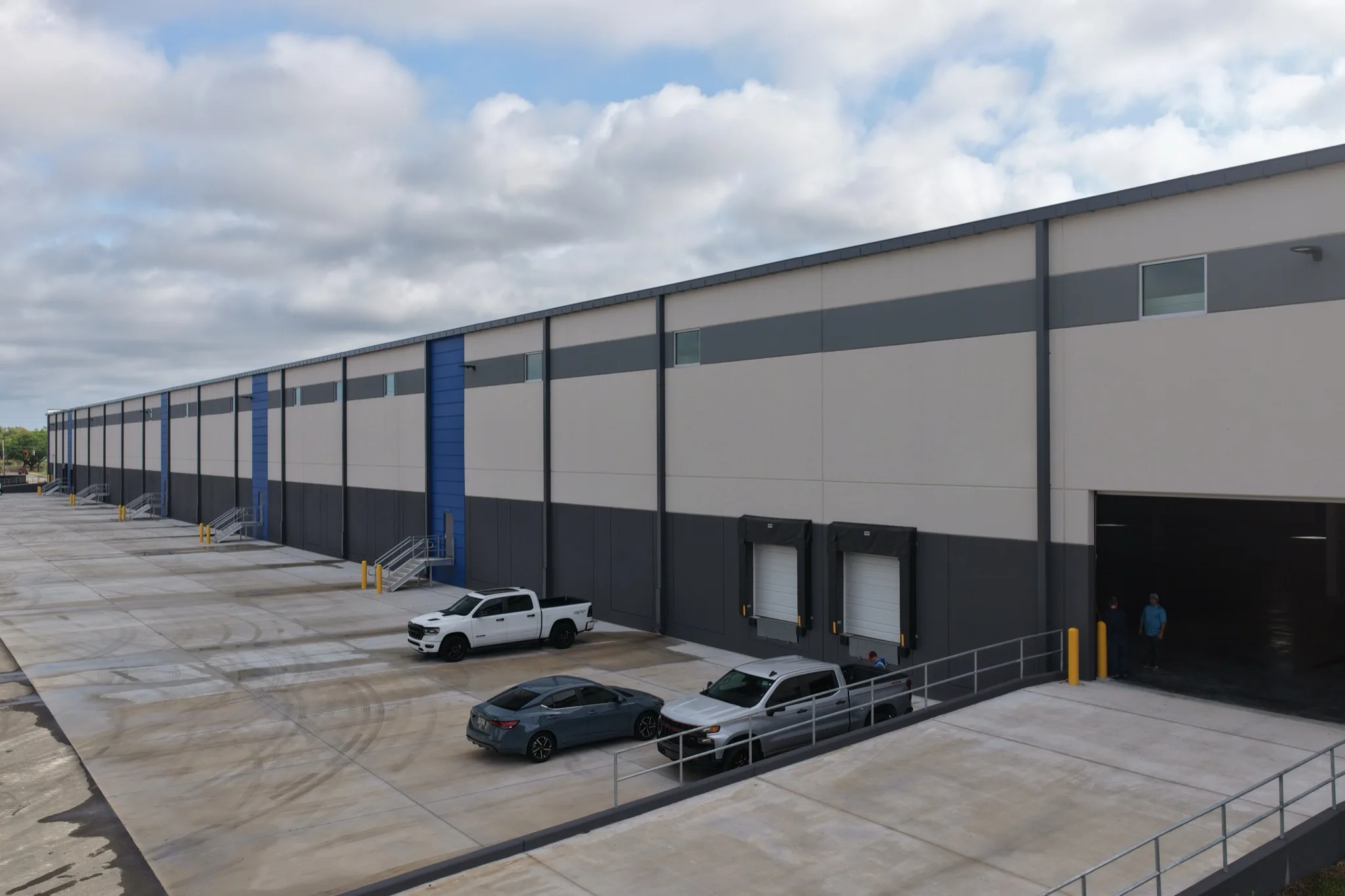 Drone aerial of 1-800-PACK-RAT loading docks and exterior parking with fresh striping Tampa by Radiant Striping