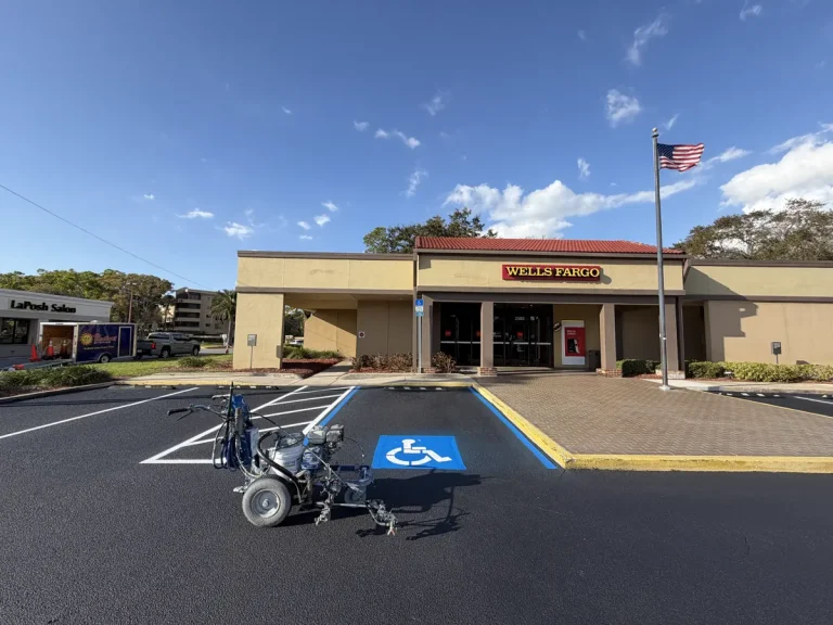 ADA compliant handicap parking space with wheelchair symbol and blue border markings at Wells Fargo commercial property - professional ADA striping by Radiant Striping Tampa Florida