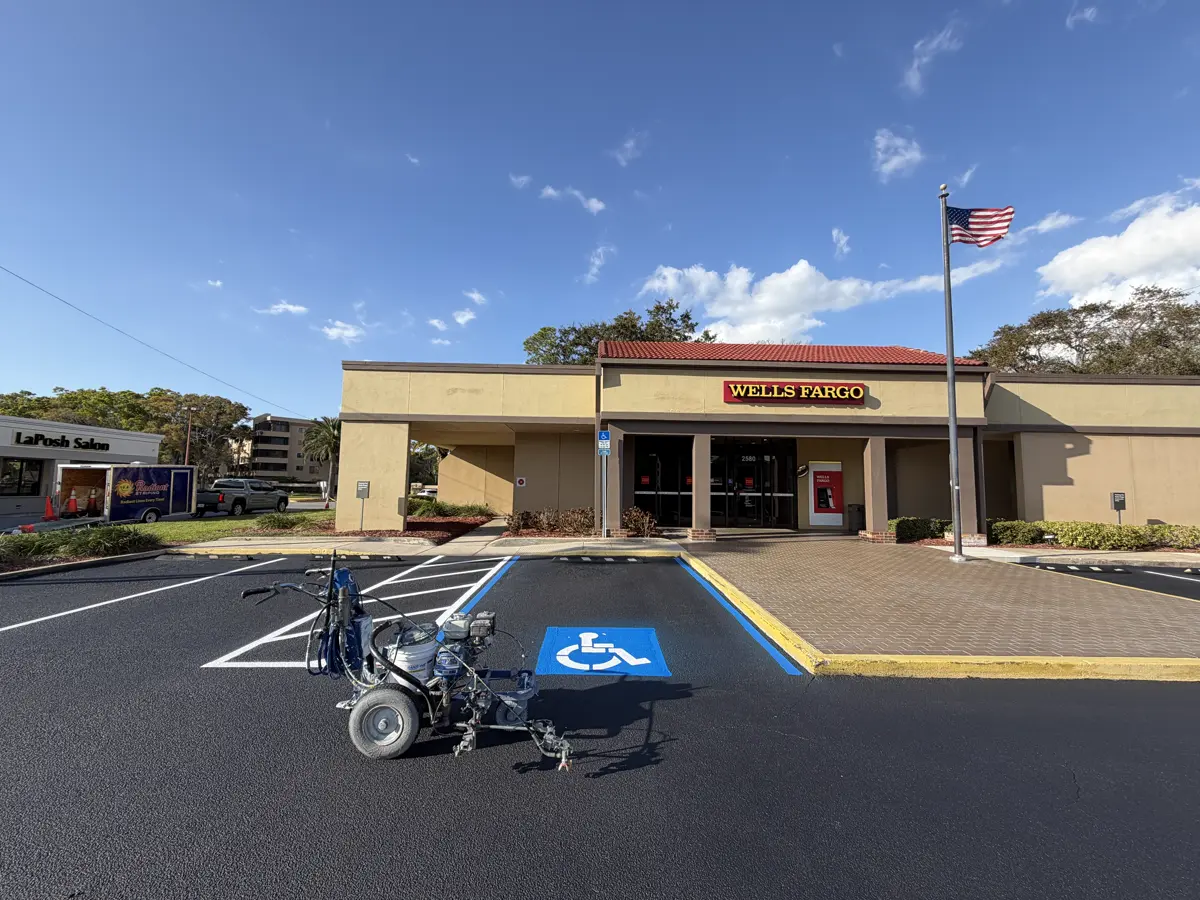 ADA compliant handicap parking space with wheelchair symbol and blue border markings at Wells Fargo commercial property - professional ADA striping by Radiant Striping Tampa Florida