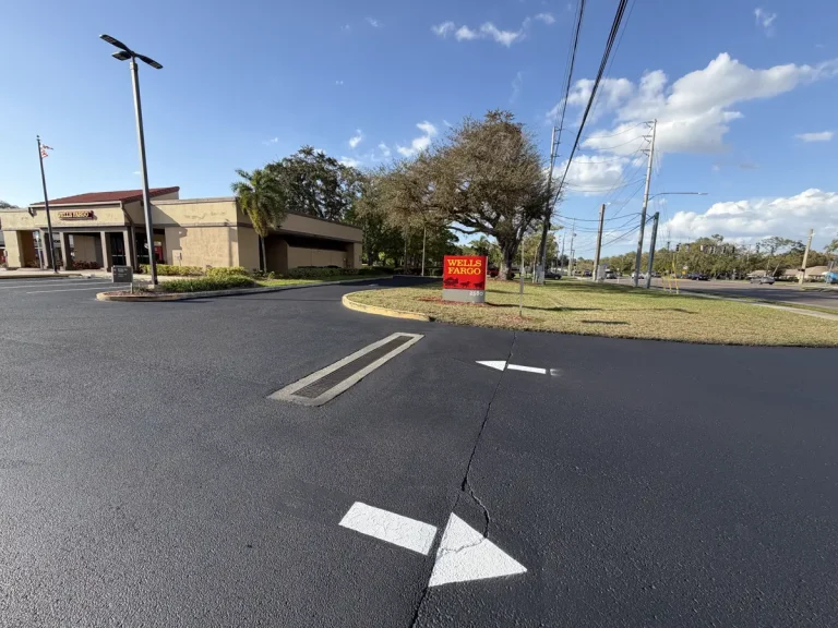 Sealcoated parking lot with directional arrows at commercial entrance Clearwater Florida by Radiant Striping