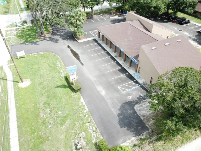 Aerial view of completed parking lot striping with ADA spaces at a commercial office in Brandon, Florida, by Radiant Striping