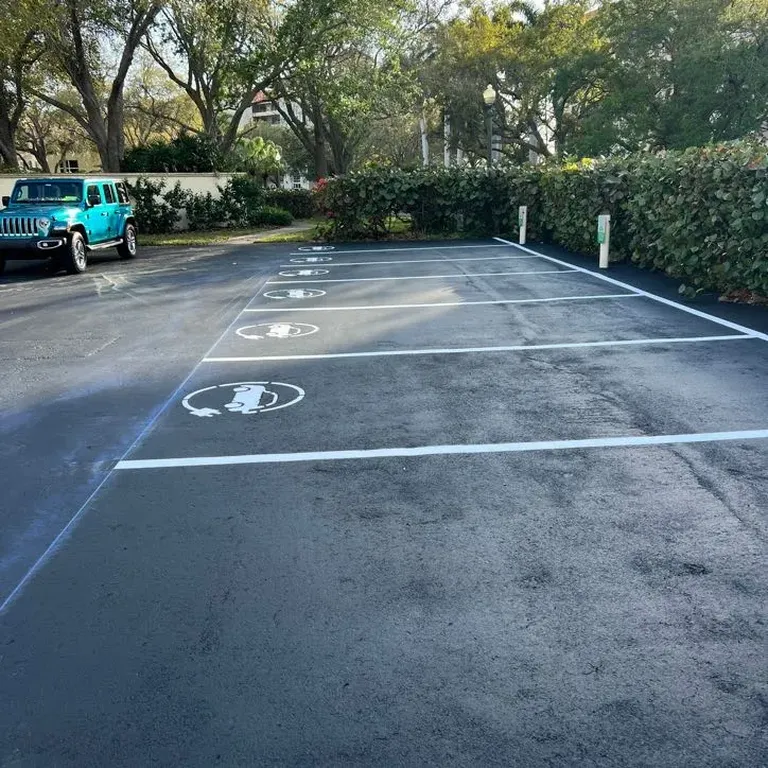 EV charging stalls with fresh sealcoating and striping at a property in St. Petersburg, Florida, completed by Radiant Striping