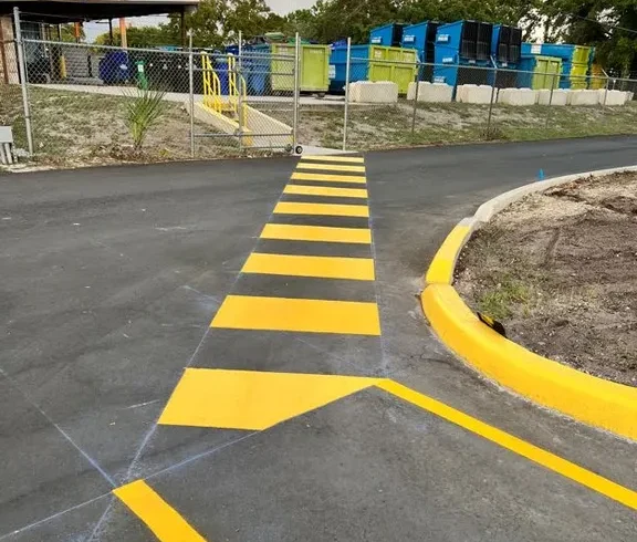Fresh yellow crosswalk and directional arrow striping at a commercial property in Largo, Florida, completed by Radiant Striping