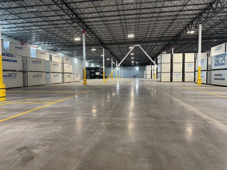 Warehouse floor striping with yellow lane markings at a 1 800 PACK RAT facility in Tampa, Florida, completed by Radiant Striping